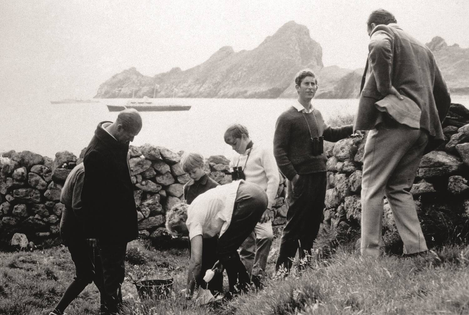 Black and white photo of five people on St Kilda, including Prince Charles.