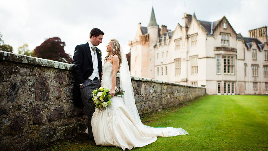 Wedding couple standing in front of Brodie Castle. 
