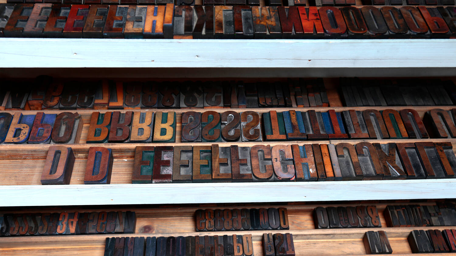 Rows of wooden letter blocks, used for printing, are lined up in special wooden cases.