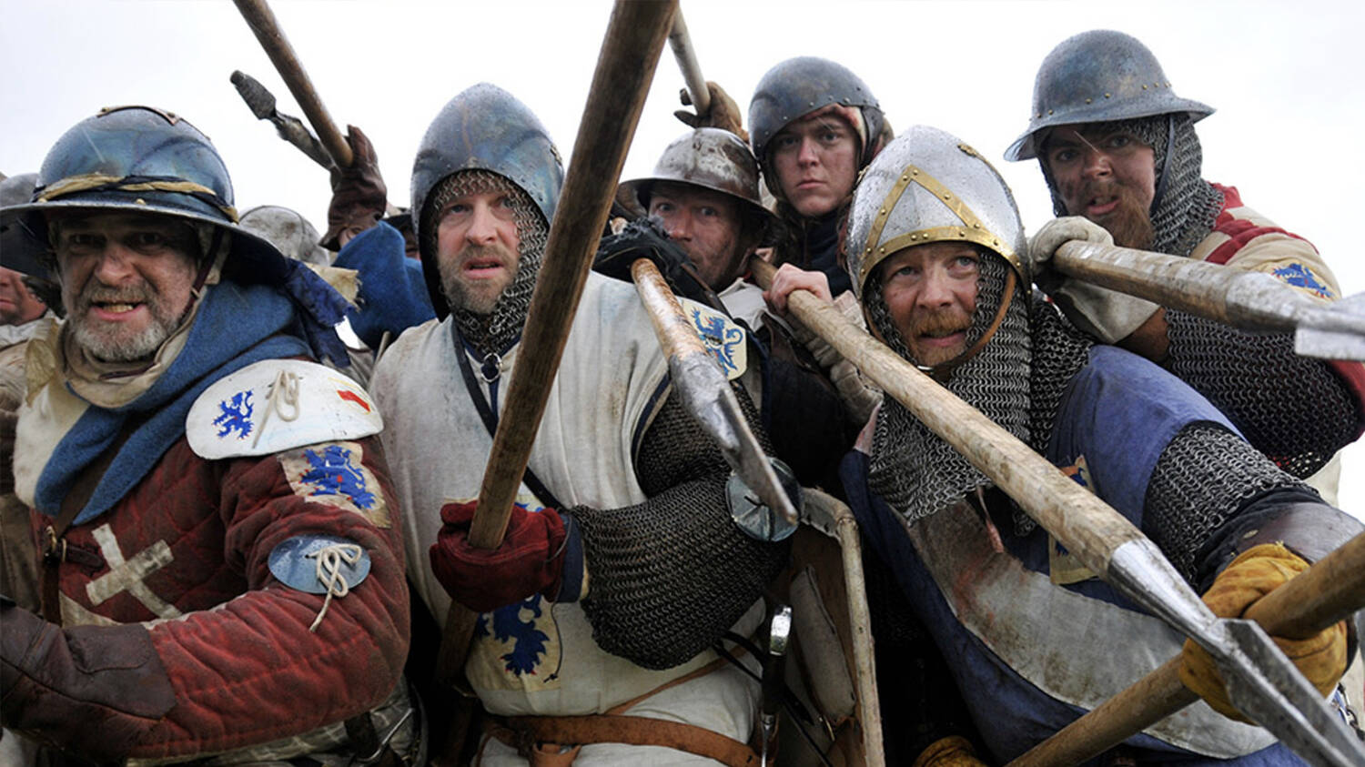 A Living History re-creation of a group of solders fighting in the Battle of Bannockburn. They are wearing helmets and chest armour, and huddle together, brandishing spears and shields.