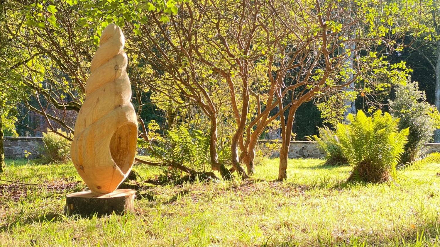 Large wooden sculpture in a woodland shrubbery.