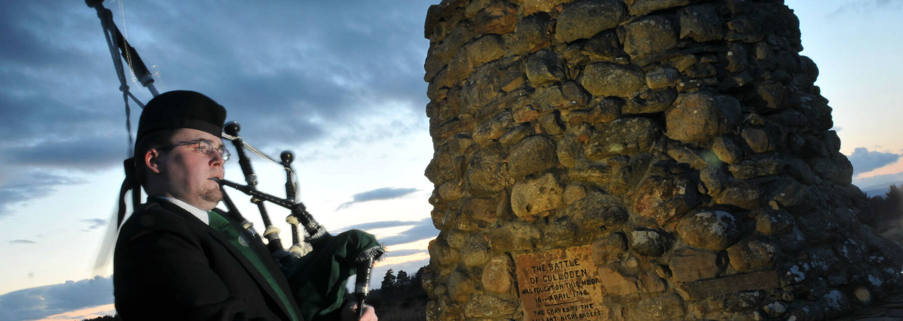 Piper at the memorial cairn at Culloden Battlefield