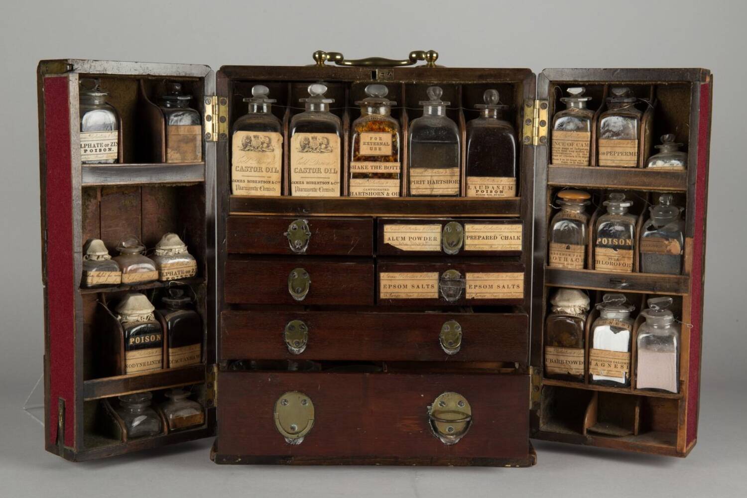 An old-fashioned medicine chest, which is open to show the different bottles and packages containing various 'cures'.