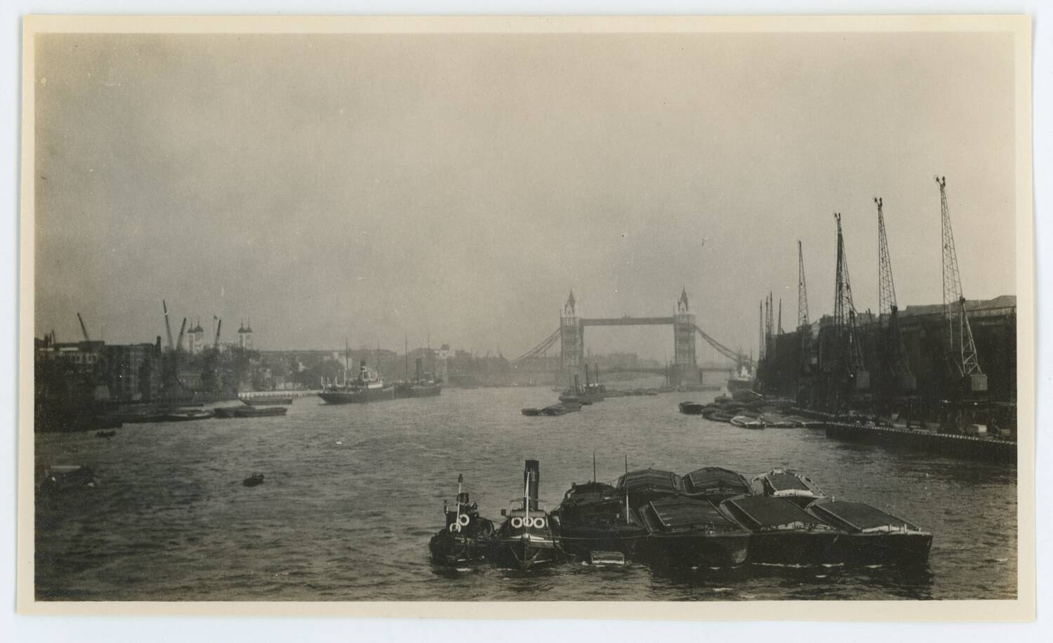 Black and white photograph of the River Thames with Tower Bridge in the background.