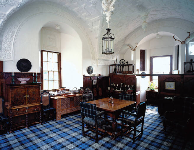 Blue tartan carpet and wooden furniture adorn the Hall in Craigievar Castle