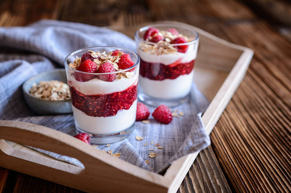 A glass of Cranachan - traditional Scottish dessert with whipped cream, roasted oatmeal and raspberries