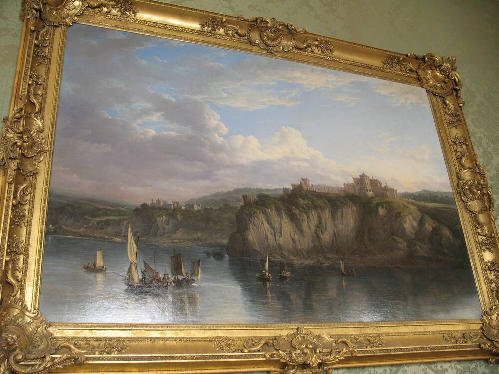 An oil painting of Culzean Castle, seen from the sea, is framed by an elaborate gold frame. It hangs on a wall with green wallpaper.