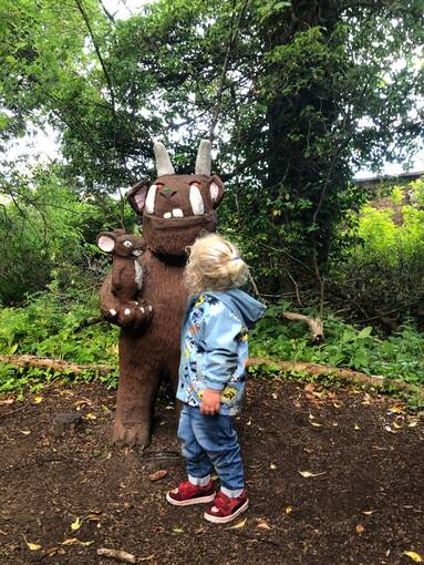 A young child studies the Gruffalo and Mouse statue at Culzean Castle