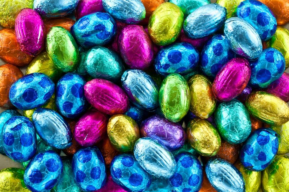 Lots of small, brightly coloured, foil-covered mini chocolate eggs