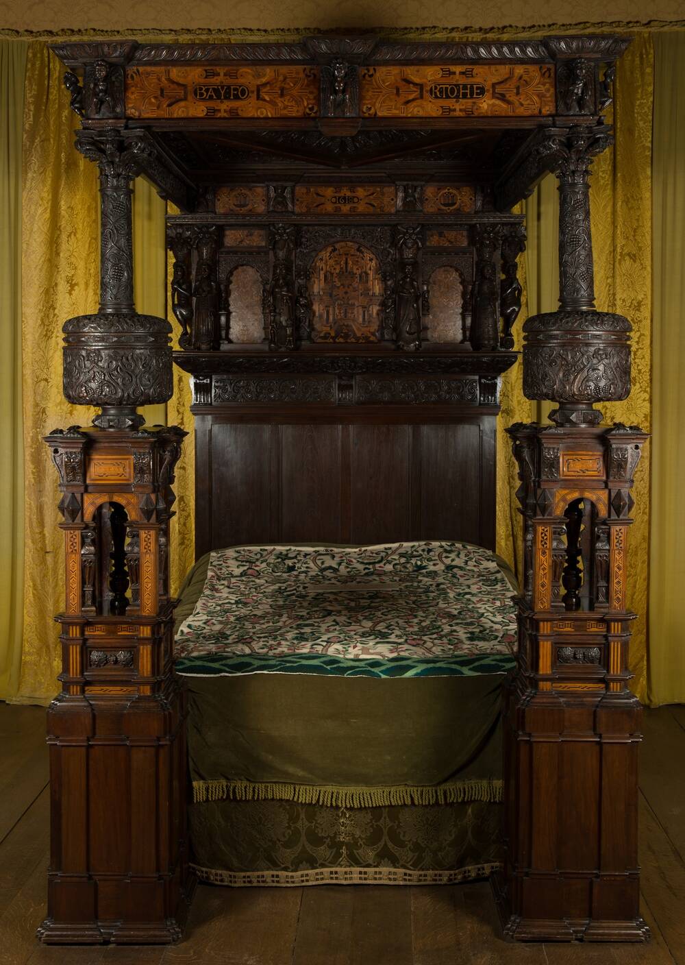 An elaborate bed with a frame carved from oak, with beautiful fruitwood and ebony marquetry.