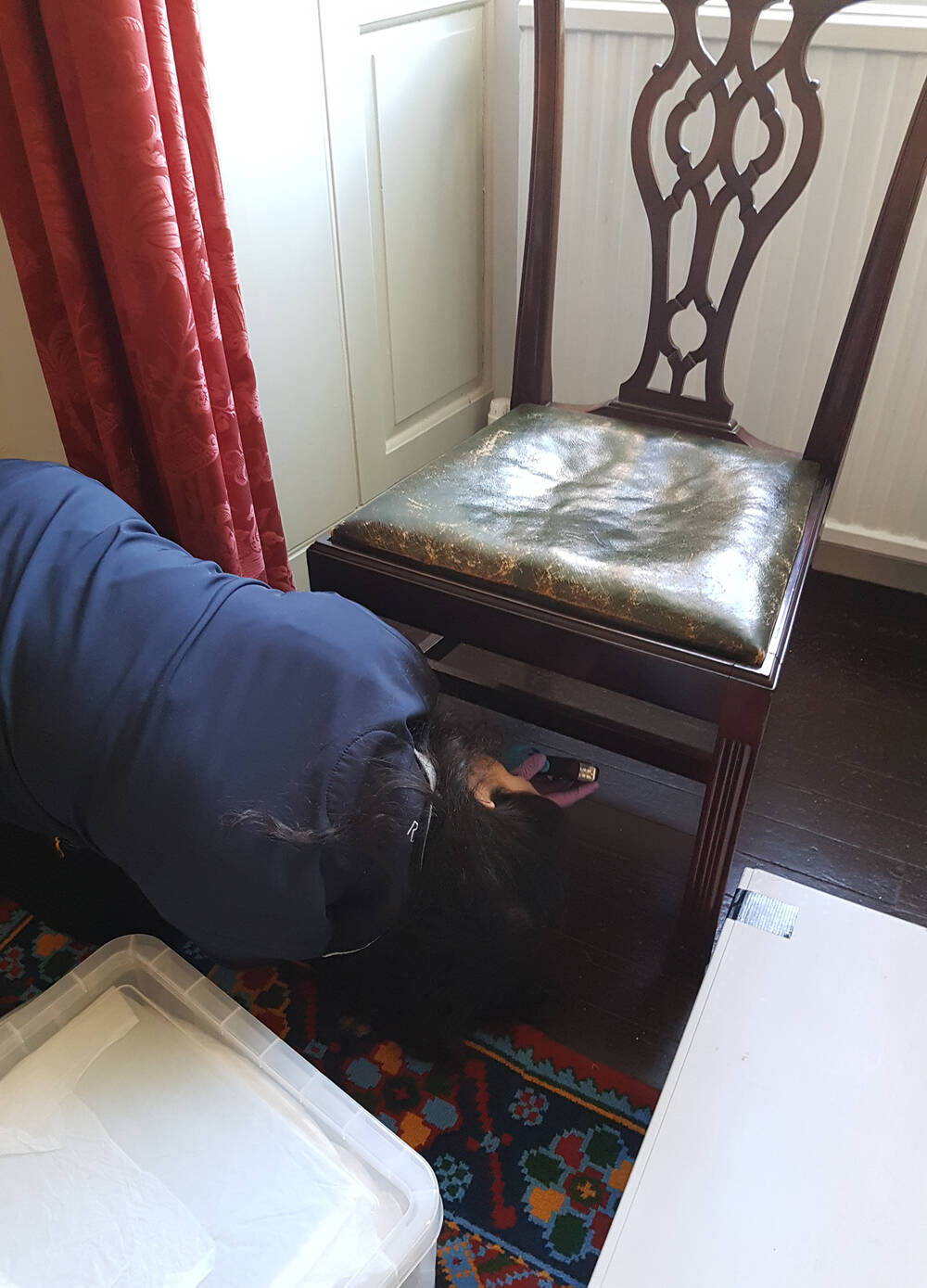 Demi checking the underside of a chair for an object number at Greenbank House