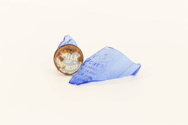 Pieces of blue glass and the lid from an old milk of magnesia bottle