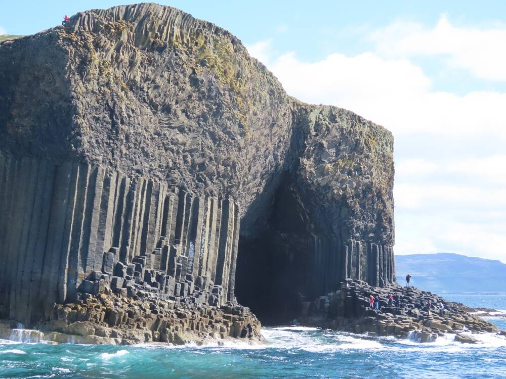 ​Fingal’s Cave on Staffa seen from the sea, with waves crashing to the shore.