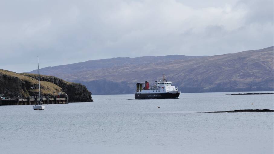 A ferry sailing into an island harbour.