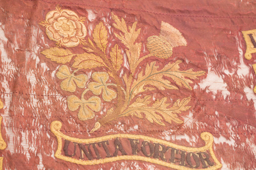 Image of the thistle, rose and shamrock with motto