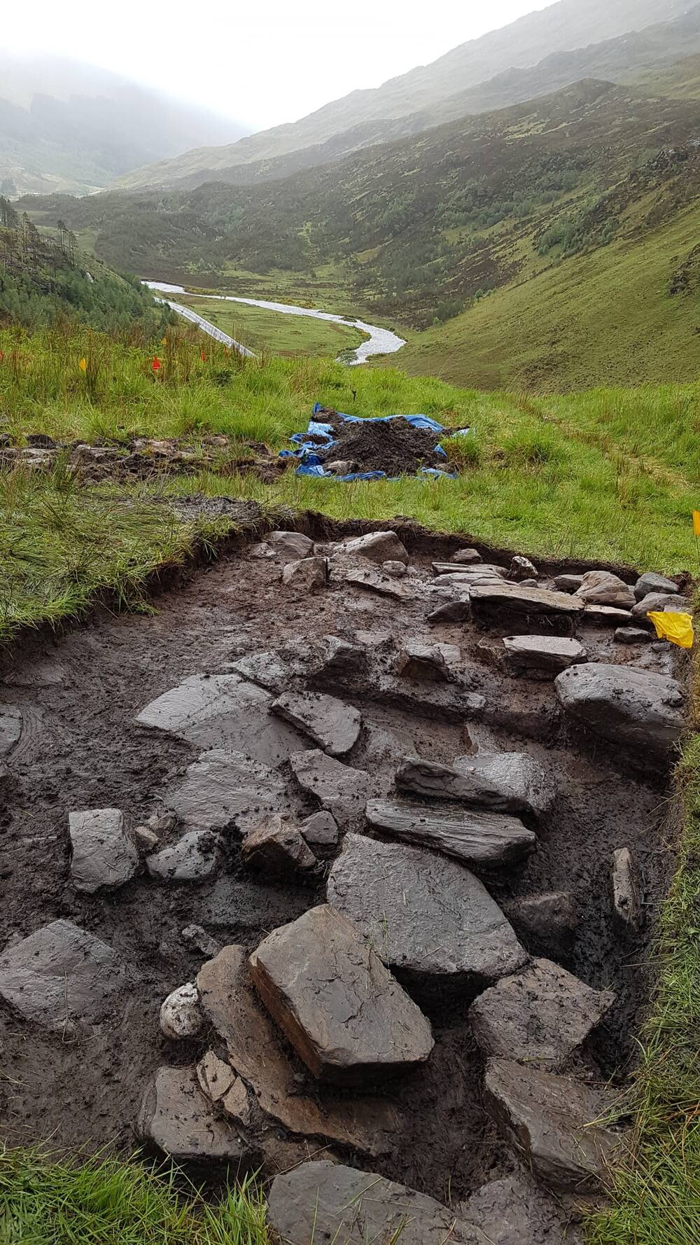 Stones uncovered by an archaeological dig in a remote valley, which is shrouded in drizzle.