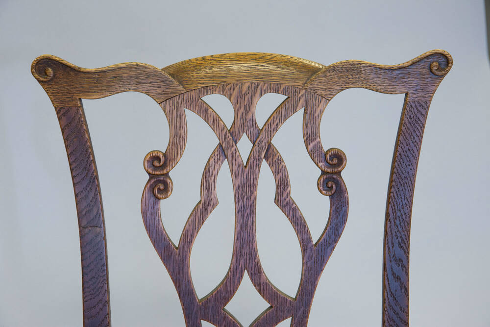 The top half of the back of an elaborately carved wooden chair.